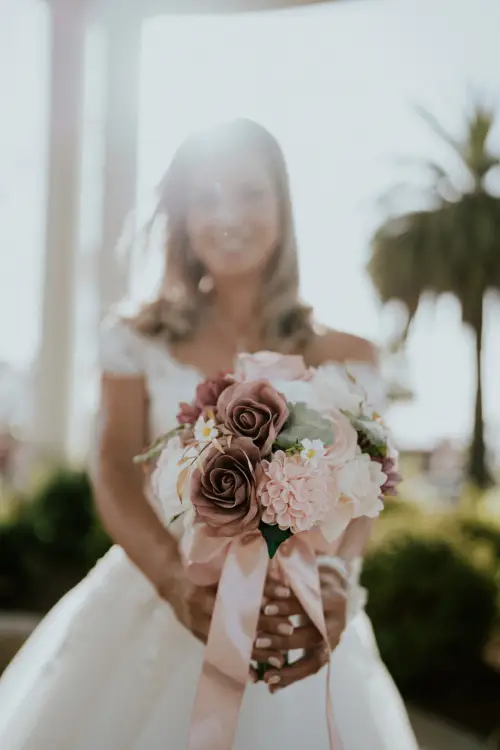 Novia posando feliz junto a su ramo de flores