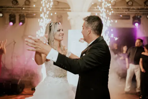 Novios bailando el vals con chispas de fondo