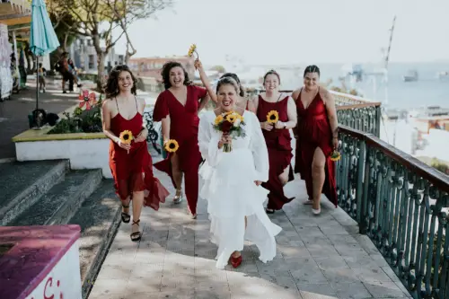 Novia feliz, corriendo junto a sus damas de honor
