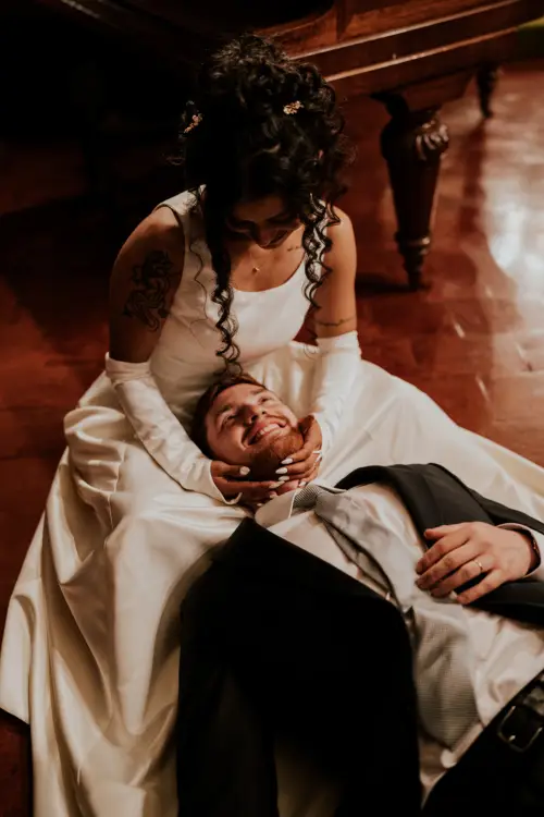 Novio acostado junto al vestido de novia de forma amorosa