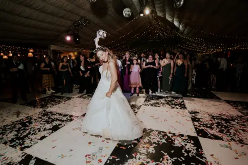 Novia feliz a punto de tirar su ramo de novia a sus invitadas